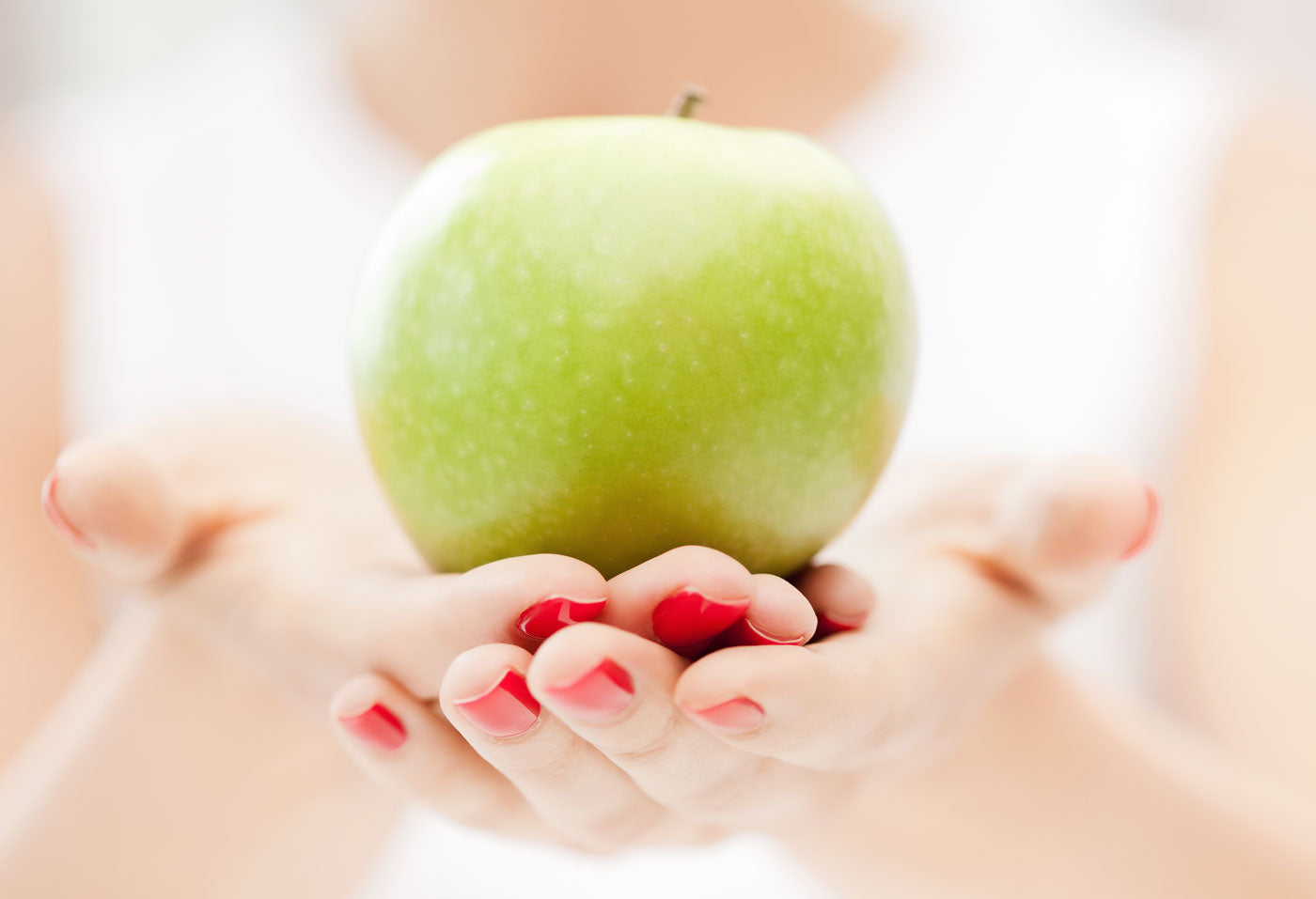 image of woman holding green apple