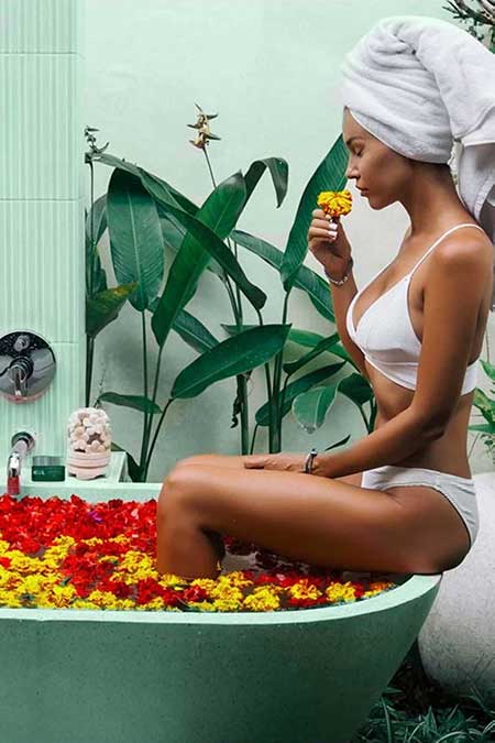 image of a woman relaxing in a bathtub full of flowers
